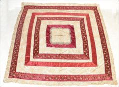 An early 20th century Edwardian silk and lace large bed spread having deep red ground panels with