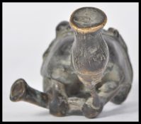 A 19th century lost wax cast bronze figure of an African shaman in a seated position with amulet