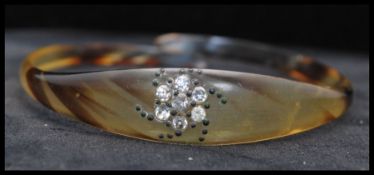 A Victorian carved horn bangle bracelet with paste set motif. Measures 3 inches diameter.