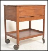 A mid century beech wood veneer sewing box cabinet set on to trolley wheels and raised on squared