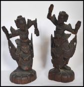 A pair of early 20th century Chinese / Asiatic wooden hand carved figurines of Buddhas / deities