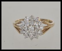 A hallmarked 9ct gold white stone cluster ring having a split band design. Hallmarked Birmingham.
