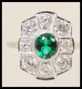 A stamped sterling silver ring in the Art deco style set with a central oval cut green stone and