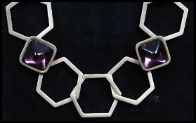 A 1970s signed YSL Yves Saint Laurent gold-tone runway necklace being strung with large geometric