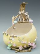 An Austrian jardinere in the form of an egg with figural dog surmount and applied decoration of