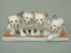 Herend porcelain figure of four dogs on a plinth, hand painted, Herend mark to base, height 5.