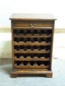 An oak 30 bottle wine rack with slide out shelving and a single drawer,
