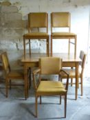 A retro Gordon Russell light oak extending dining table and five leatherette upholstered chairs,