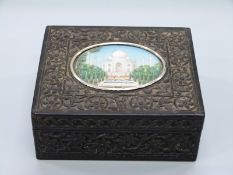 An early 20thC Anglo Indian carved ebony box with inset oval miniature of the Taj Mahal,