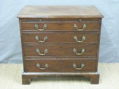 A Georgian mahogany bachelor's chest of four graduated drawers with brushing slide,