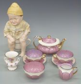 A lustre ware tea for two and a whimsical figure of a child on a potty 28cm high