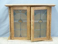 An oak lead glazed Arts and Crafts hanging cupboard with breakfront top together with a pot