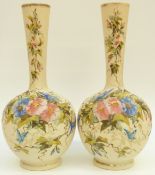 A pair of Victorian glass bottled vases with enamel decoration of flowers and butterflies on a