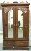 A carved Victorian/Edwardian walnut wardrobe with twin bevelled mirror doors and two drawers,