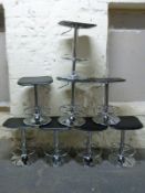 Eight modern upholstered chrome stools with adjustable height and footrests