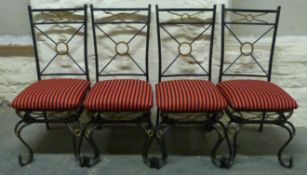 A set of four wrought iron chairs with padded seats