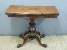 A Victorian burr walnut games table raised on a quatrefoil base and ceramic castors,