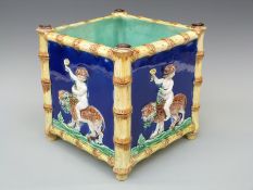 A 19thC continental majolica jardiniere of square form framed with bamboo moulding,