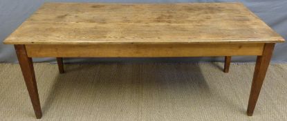 An oak farmhouse style kitchen or dining table raised on square tapering legs,