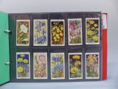 A collection of cigarette cards in four albums, includes Players & Wills,