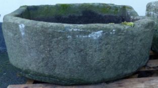 A carved natural stone D shaped trough,
