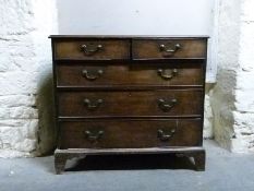 A Georgian mahogany chest of two over three graduated drawers raised on bracket feet,