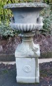 A reconstituted stone jardiniere on a plinth,