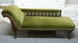 A Victorian chaise longue upholstered in green velvet, raised on turned legs and castors,
