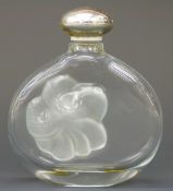 Lalique Nina Ricci clear glass scent bottle with frosted flower decoration and silver coloured top,