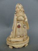 A 19thC carved ivory figure of a scholar with mother of pearl cabochons,