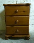 A pine bedside chest of three drawers,