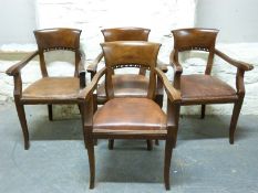 A set of four mahogany leather upholstered armchairs with curved pierced backs,