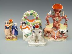 Four 19thC Staffordshire spill vases including a horse and cow drinking from a trough,