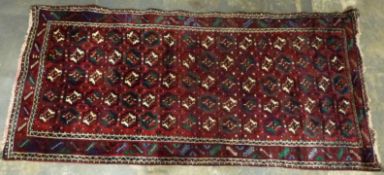 A fine Belouch wool rug on wine ground,