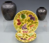 Two Poole Pottery vases and two majolica plates by Sarreguemines