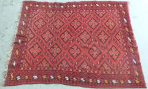 A large Afghan rug with central design of multiple diamond guls and orange,