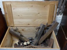 A large wooden chest containing a large collection of wooden vintage planes, bows,