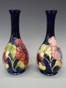 A pair of Moorcroft pedestal vases in the Hibiscus pattern,