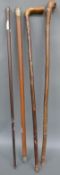 Four walking sticks including a sword stick and silver topped example