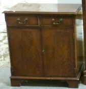 A reproduction mahogany cupboard and a Chippendale style upholstered chair,