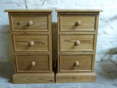A pair of pine bedside chests of three drawers,