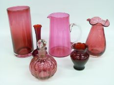 Six pieces of cranberry and ruby glassware including a Kings Lynn cylindrical vase (23cm tall),