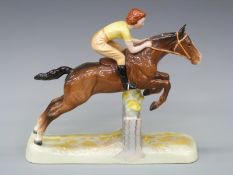 A Beswick figure of a girl on a horse jumping a fence,
