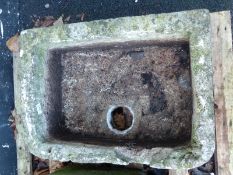 A carved natural stone trough with shaped corners,