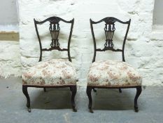 Two nursing or salon chairs raised on cabriole legs and ceramic castors