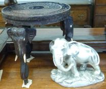A carved Anglo-Indian table with elephant decoration and a model of an elephant