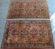 A near pair of silk or fine wool rugs on pink ground,
