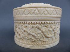 A 19th/early 20thC carved ivory lidded circular pot with dragon decoration (no base),