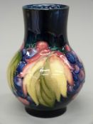 Moorcroft pedestal vase in the Leaf & Berry pattern, impressed Moorcroft to base, 12.