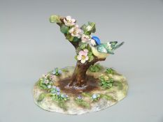 Royal Crown Staffordshire large model of a blue tit on a bough among blossom, signed Jones to base,